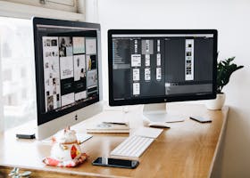 A well-organized design workspace with dual monitors and design software on display.